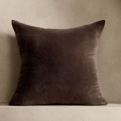 a brown pillow sitting on top of a white shelf