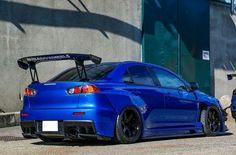 a blue sports car parked in front of a building