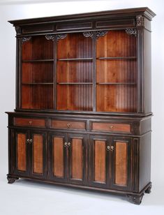 an old fashioned bookcase with wooden doors and carvings on the front, sitting against a white background