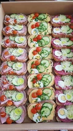 a box filled with lots of different types of sandwiches and veggies on top of each other