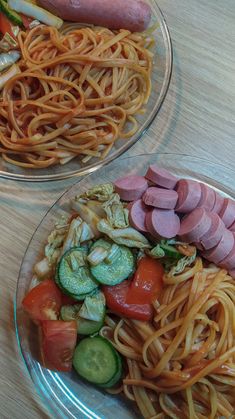 two plates filled with different types of food on top of a wooden table next to each other