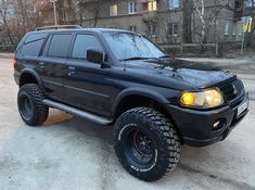 a black suv parked in front of a building