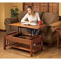 a woman sitting on top of a brown couch next to a table with a book