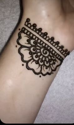 a woman's wrist with a henna tattoo on it