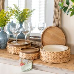 wicker baskets and wine glasses sit on a mantel