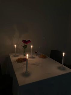 three candles are lit at the end of a dinner table