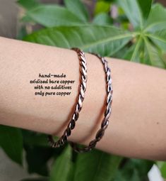 a woman's arm with two bracelets that have words written on the wrist