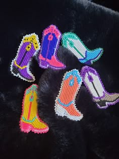 six pairs of beaded cowboy boots on a black background