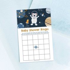 a baby shower bingo game with an astronaut bear on the space shuttle and planets in the background