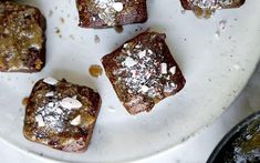 some brownies are on a plate with white powdered sugar and sprinkles