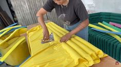 a woman in grey shirt painting yellow furniture