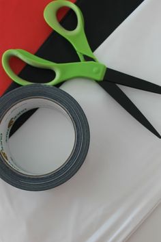 a pair of scissors sitting next to a roll of tape