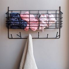 a towel rack with towels hanging from it's sides next to a white wall