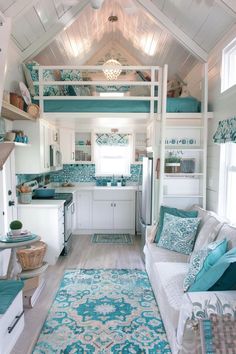 a living room filled with lots of furniture next to a kitchen and stove top oven