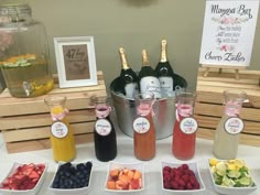 bottles of wine and fruit are on display at a baby shower or bridal party