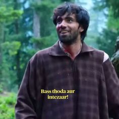 a man standing in the woods wearing a brown jacket with words on it that read bass thoda aur intezar?