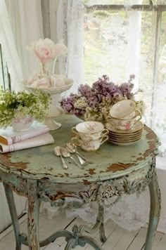 a table topped with dishes and flowers next to a window