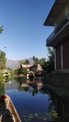 a boat traveling down a river next to houses