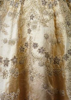 the back of a gold dress with flowers on it