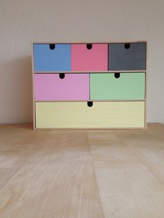 a multicolored dresser sitting on top of a wooden table