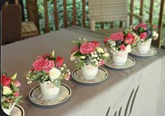 small vases filled with flowers on top of a tableclothed table cloth covered dining room table