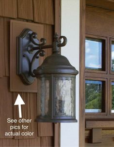 an old fashioned light hanging on the side of a house