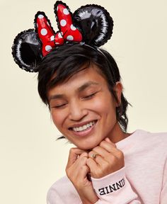 a woman wearing minnie mouse ears with her hands on her chest