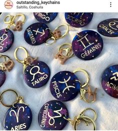 zodiac keychains with astro symbols on them sitting on a white cloth covered table