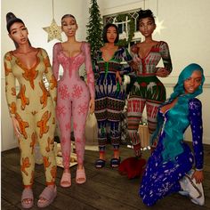 four women in colorful outfits standing next to each other on a wooden floor with christmas decorations