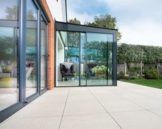 an outside patio with glass walls and sliding doors