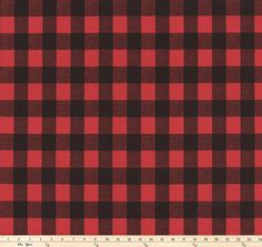 a red and black checkered fabric with a ruler in front of the plaid pattern