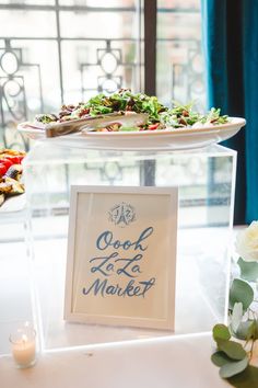 a table topped with two plates of food next to a sign that says good la la market