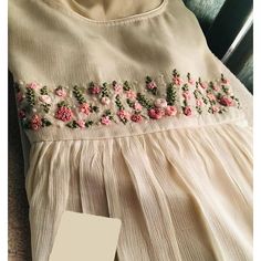 a white dress with pink flowers on it next to a card that says i love you