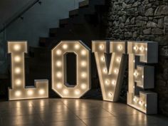 the word love is lit up with lights on it in front of some stairs and steps