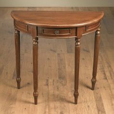 an oval wooden table with two drawers on one side and a drawer on the other