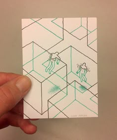 a hand holding up a piece of paper with drawings on it