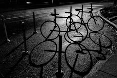 several bicycles are parked on the side of the road in front of an iron fence