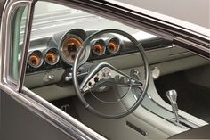 the interior of an old car with gauges and steering wheel