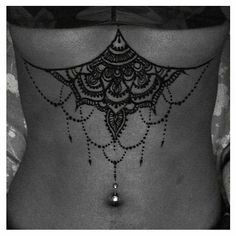 a black and white photo of a woman's stomach with an intricate design on it