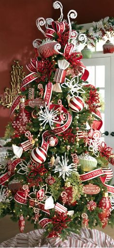 a christmas tree decorated with red and white ribbons