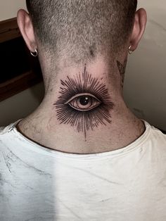 a man's neck with an all seeing eye tattoo on the back of his neck