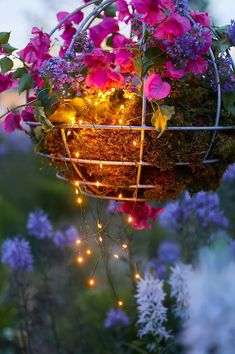 a hanging basket filled with flowers and fairy lights