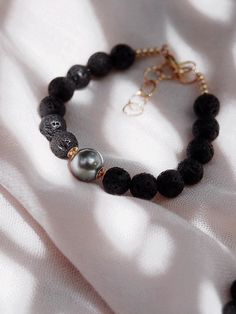 Adorned with a mix of textured lava beads and a single black Tahitian pearl, this handmade beaded bracelet is a stylish personification of Hawaii’s enigmatic allure. This stunning Tahitian pearl bracelet elegantly exemplifies mindful island living. Wear this alone or stacked for a classically elegant statement.✦ DETAILS ✦✧ Name: Roselani (rose-LAH-nee) - Heavenly Rose.✧ Adjustable Length from: 7"-8.5"✧ Genuine Tahitian Pearl 8-10mm AA-AAA quality; tone and shape varies.✧ 8mm Black Lava Beads✧ 14 Black Pearl Bracelet, Tahitian Pearl Bracelet, Lava Bead Bracelet, Hawaii Jewelry, Tahitian Black Pearls, Chunky Bracelets, Pearl Collection, Lava Bead, Tahitian Pearls