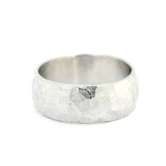 a white gold wedding ring with rough textured finish on the outside, and a black diamond in the center