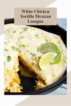 white chicken tortilla mexican lasagna in a skillet with lime wedges