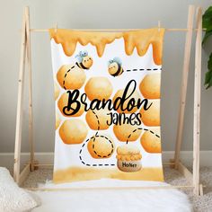 a blanket with the words brandon james on it next to a potted plant and white fur