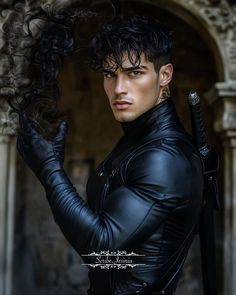 a man with black hair wearing a leather jacket and holding his hands on his hips