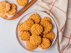 some cookies are on a white plate next to a wooden spoon