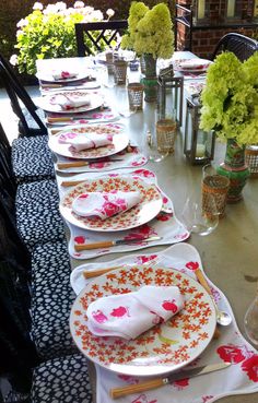 a long table is set with plates and flowers