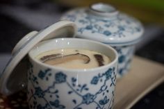 there is a cup of coffee with cream in it on the tray next to another cup